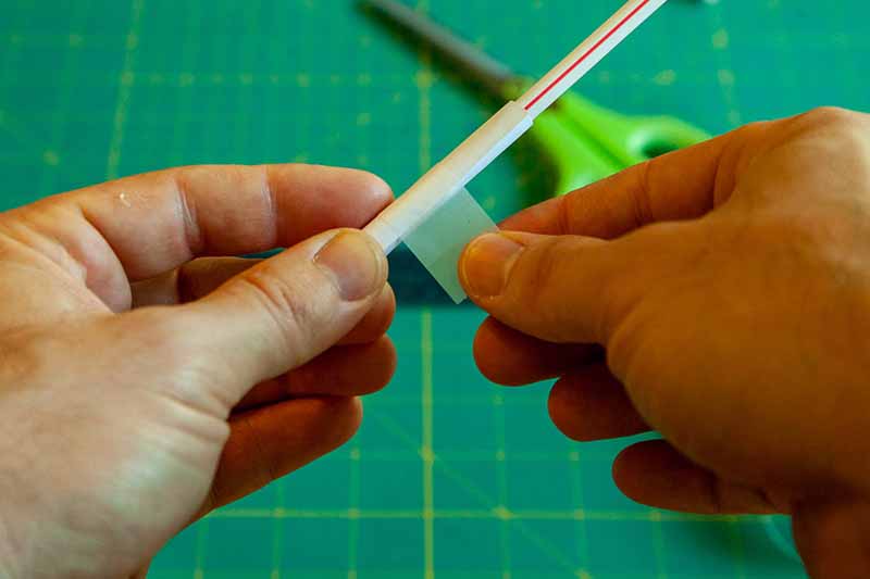 tape a rolled piece of paper around a straw