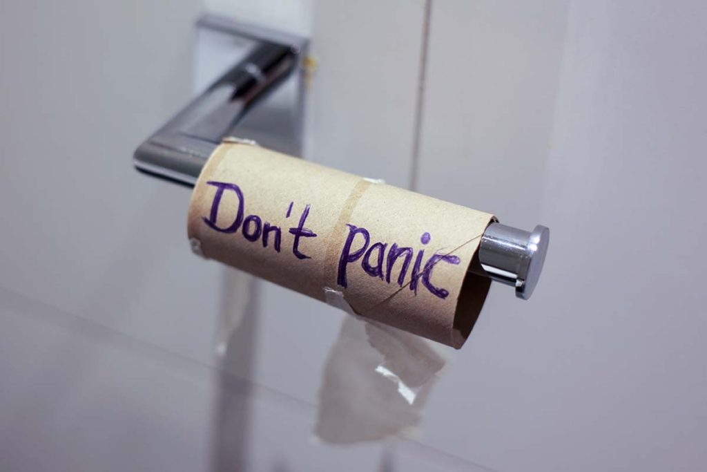 An empty toilet paper roll with Don't panic written on it