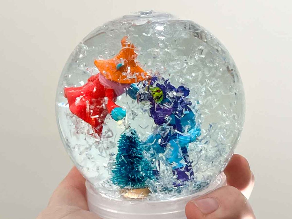 Snow globe with He-man figurines. Skeleton holding Orko