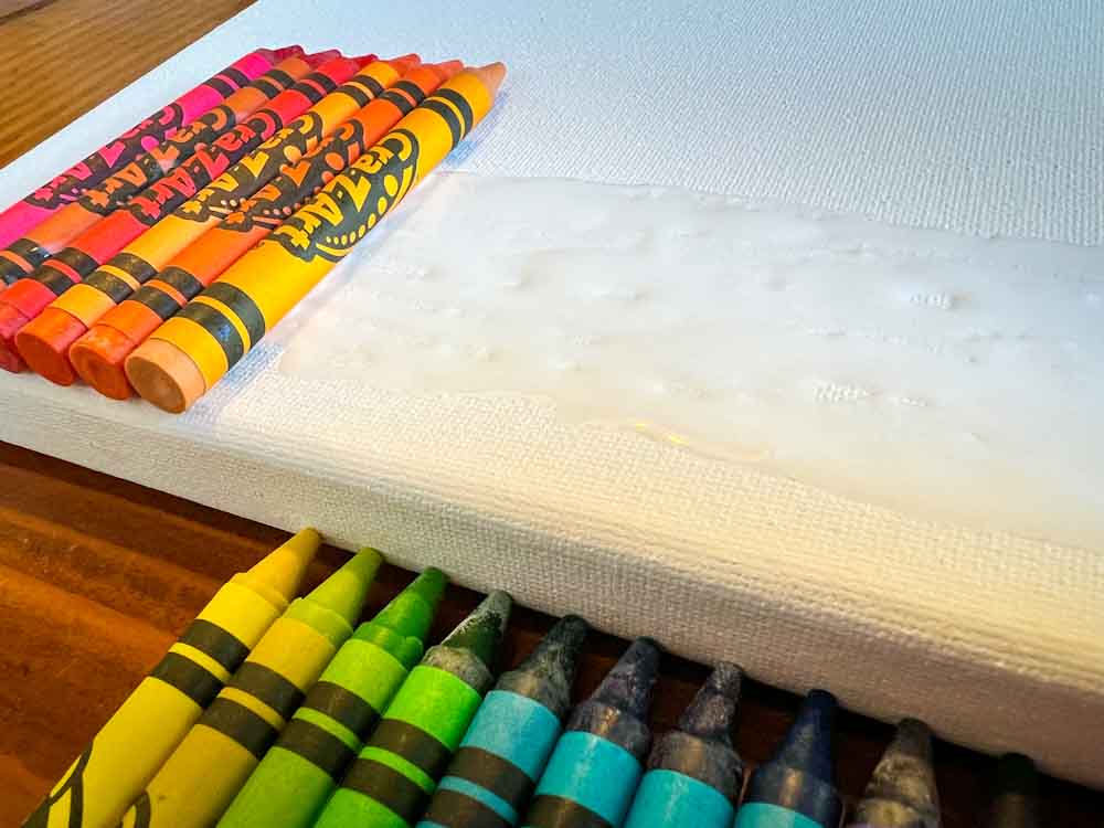 Gluing crayons to a stretched canvas using white glue